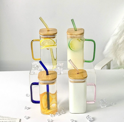 green borosilicate drink glass with a glass straw and bamboo lid in different colors